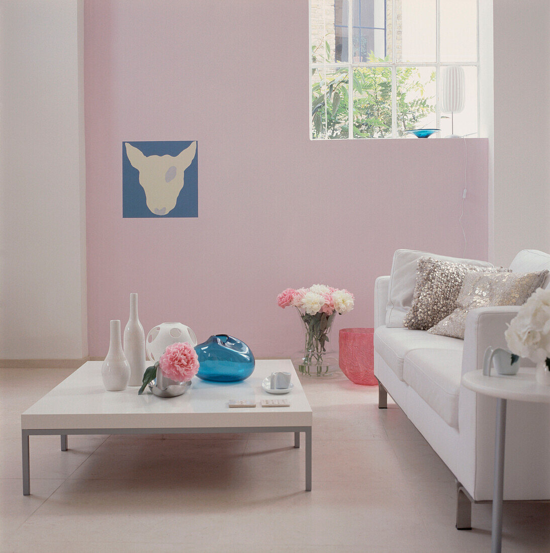 Modernes rosa-weiß-türkisfarbenes Wohnzimmer mit Sofa und Couchtisch