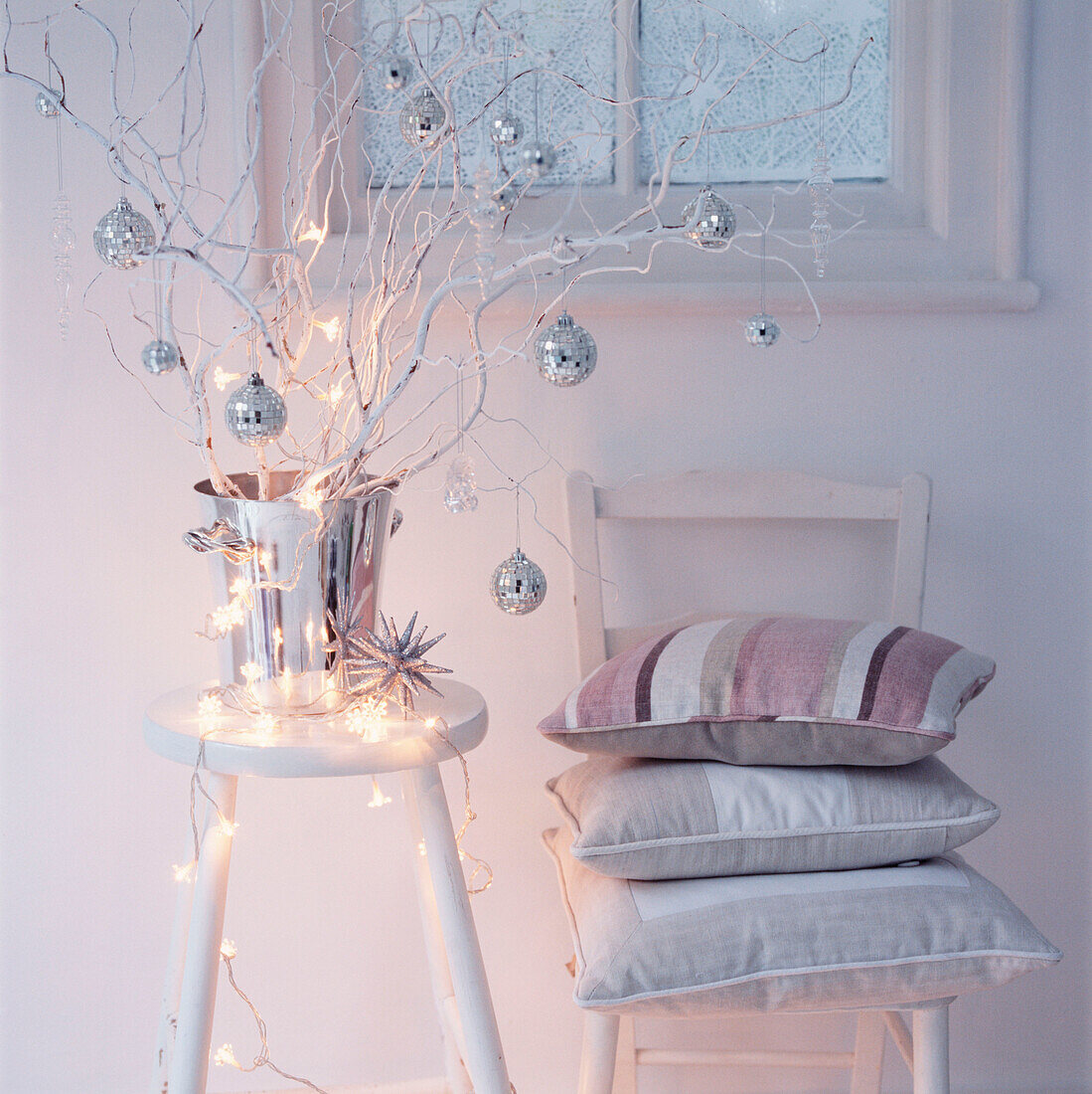 Alternativer Weihnachtsbaum, geschmückt mit silbernen Kugeln und Lichterketten in einem weißen Wohnzimmer