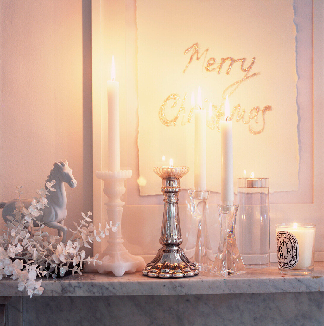 Marmorkaminsims mit brennenden Kerzen und Weihnachtsdekoration