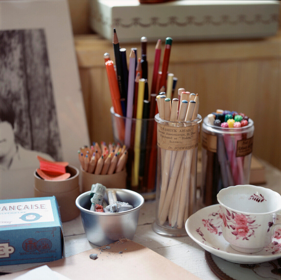 Töpfe mit verschiedenfarbigen Stiften und Bleistiften auf dem Schreibtisch eines Künstlers