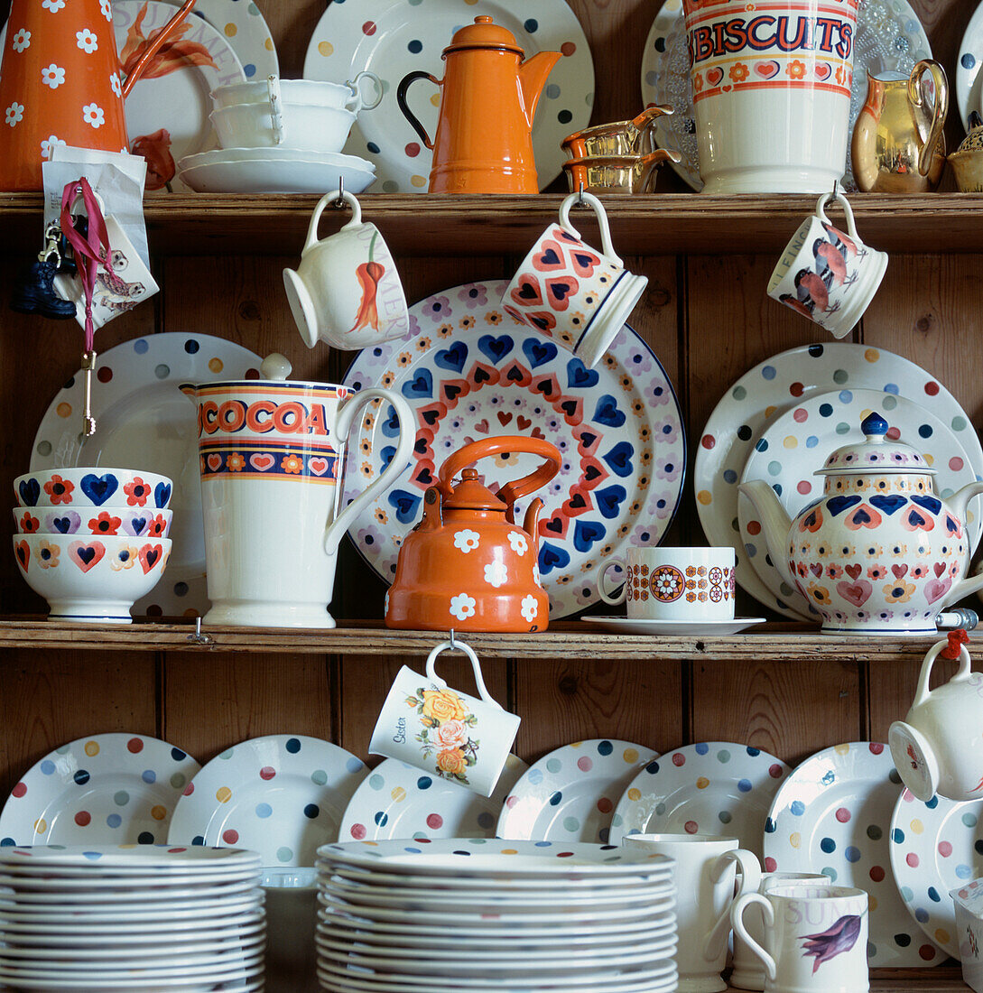 Colourful collection of crockery stacked and displayed on a kitchen dresser