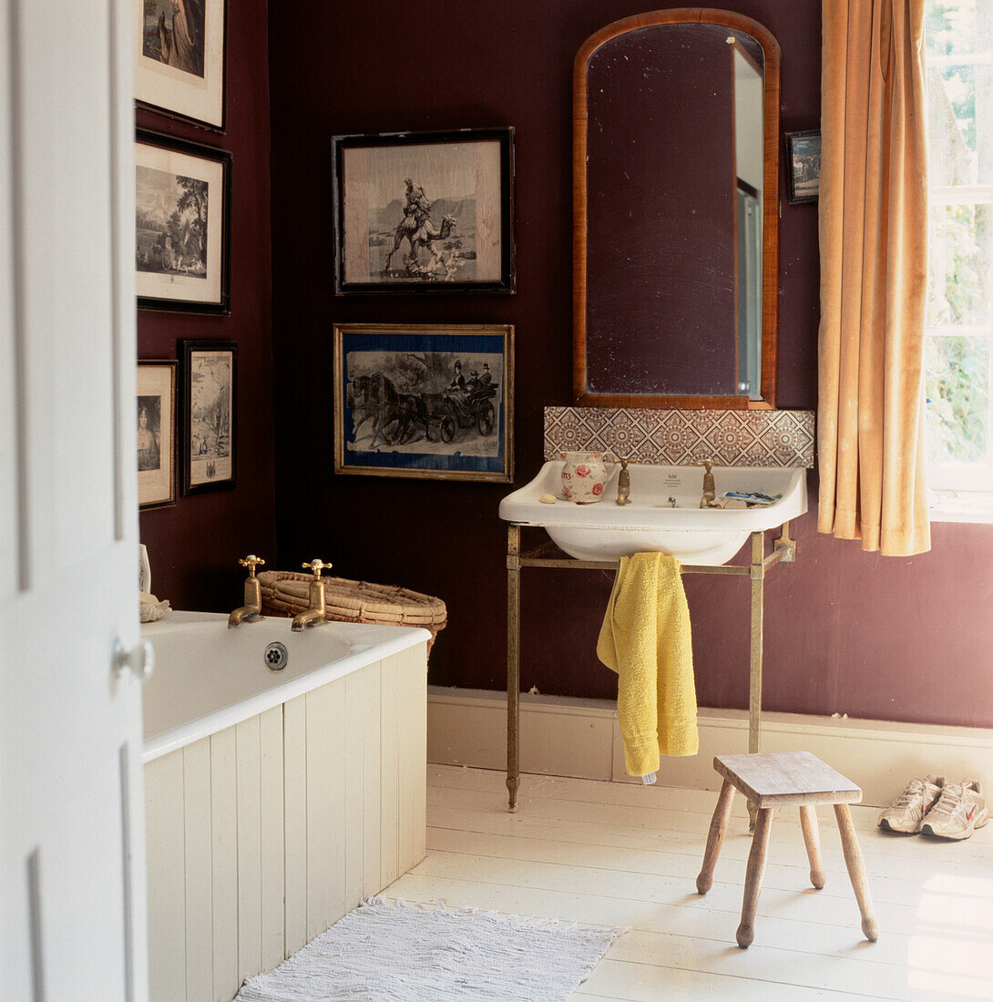 period bathroom with vintage sink and bath and dark deep purple painted walls