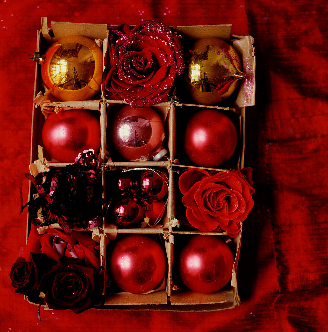 Schachtel mit rotem Weihnachtsschmuck