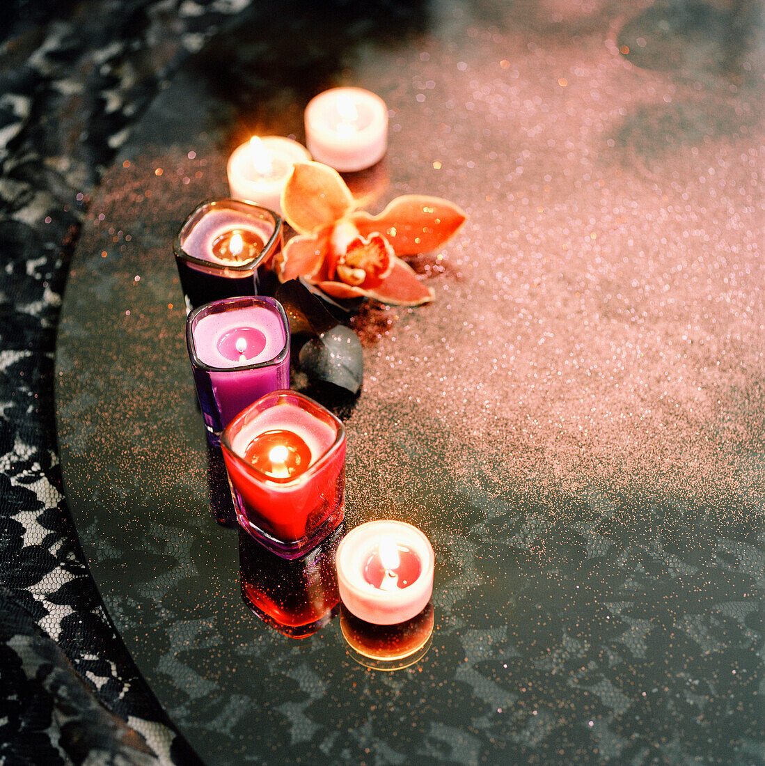 Colourful scented candles on a black tabletop