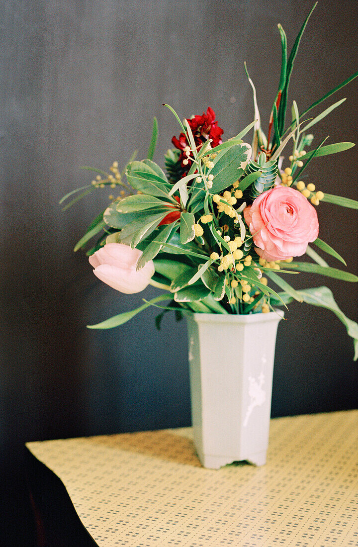 Blumenarrangement in einer Vase auf einer Tischplatte
