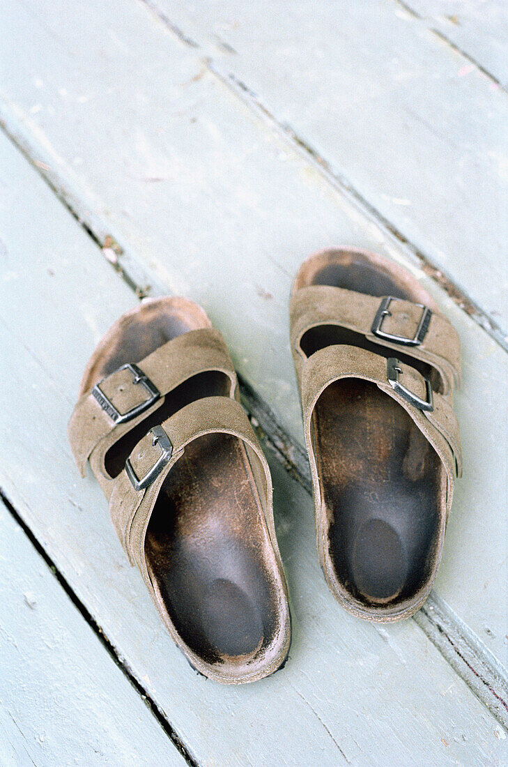 Worn sandals on a white painted wooden floor