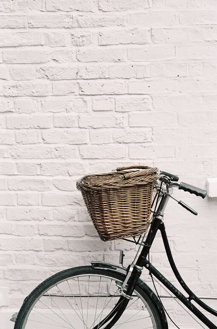 Bicycle propped up against a white brick wall