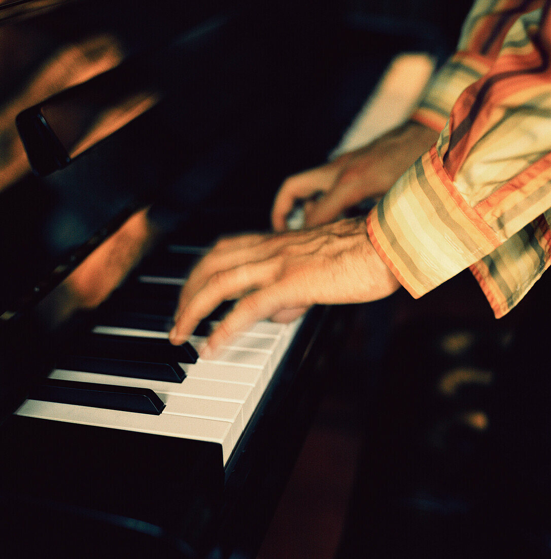 Mann spielt auf einem Klavier