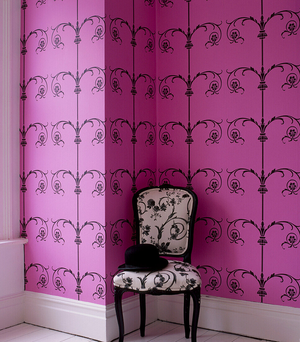 Room with pink patterned wallpaper and upholstered chair