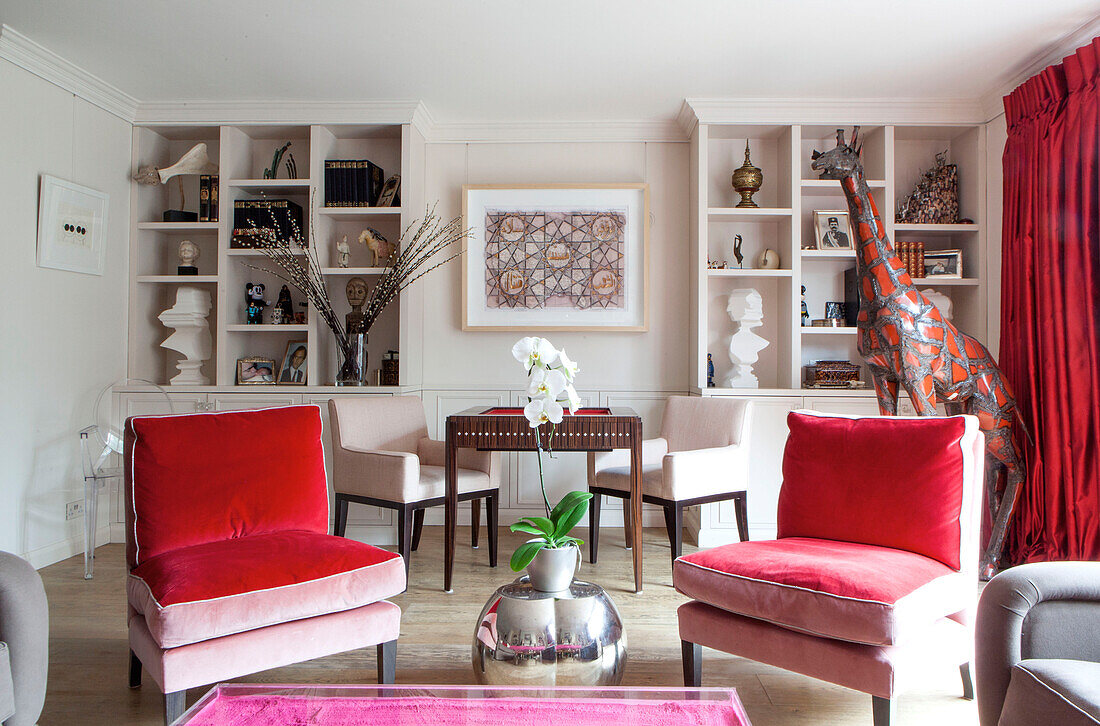 Passende Stühle und Bücherregal mit Giraffenstatue im Wohnzimmer eines modernen Londoner Hauses England UK