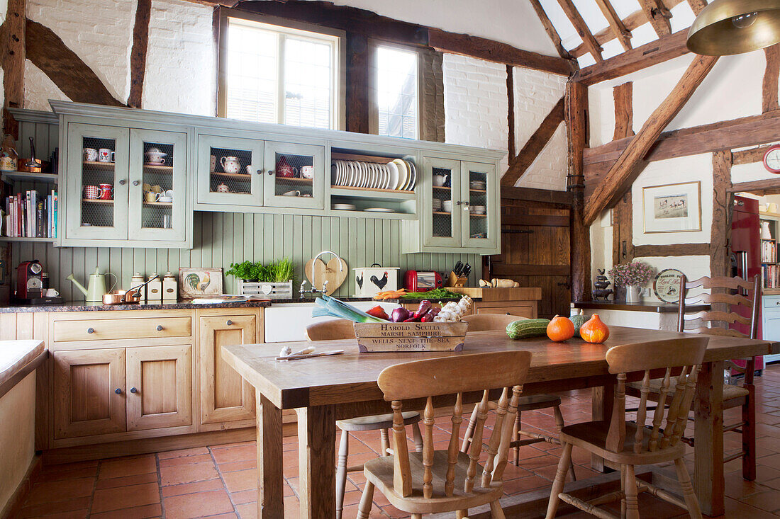 Timber framed kitchen with light green fitted units in Surrey barn conversion England UK
