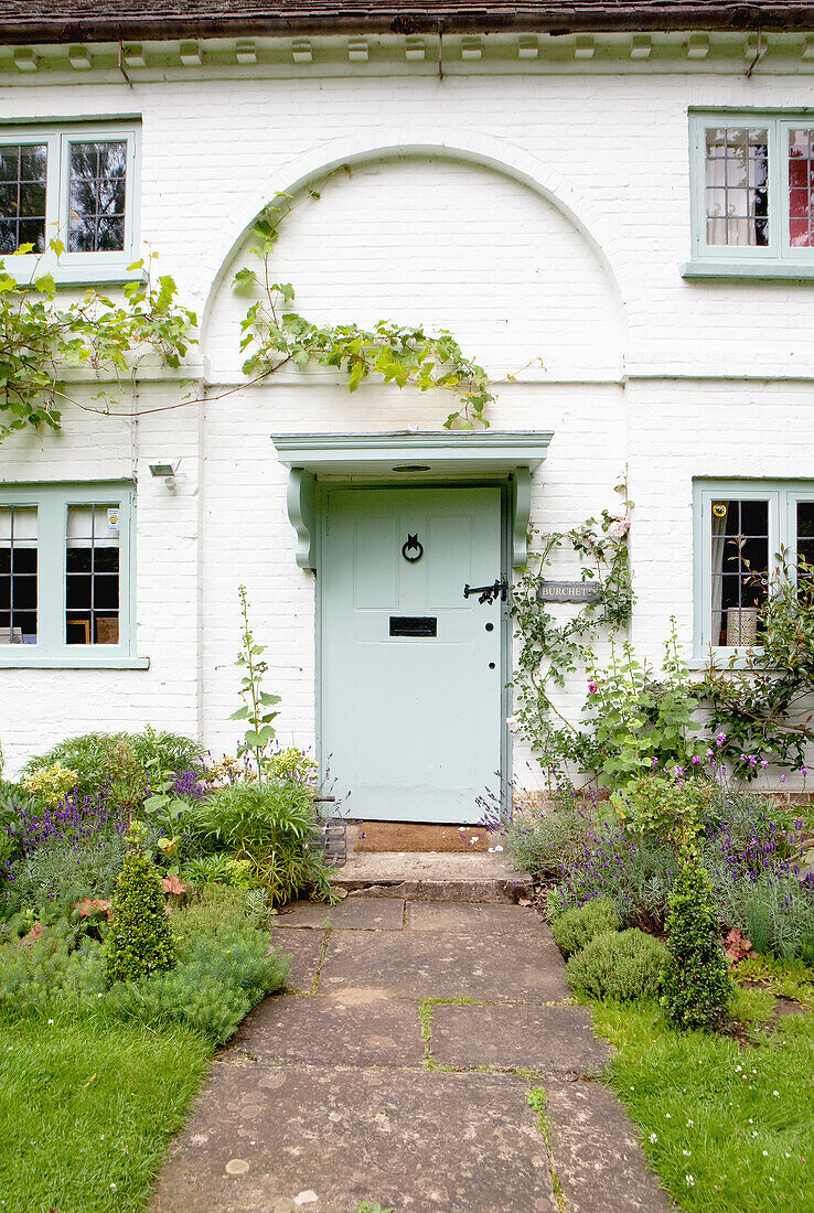 Hellgrüner Anstrich an der Außenseite eines weiß getünchten Landhauses in Surrey England UK