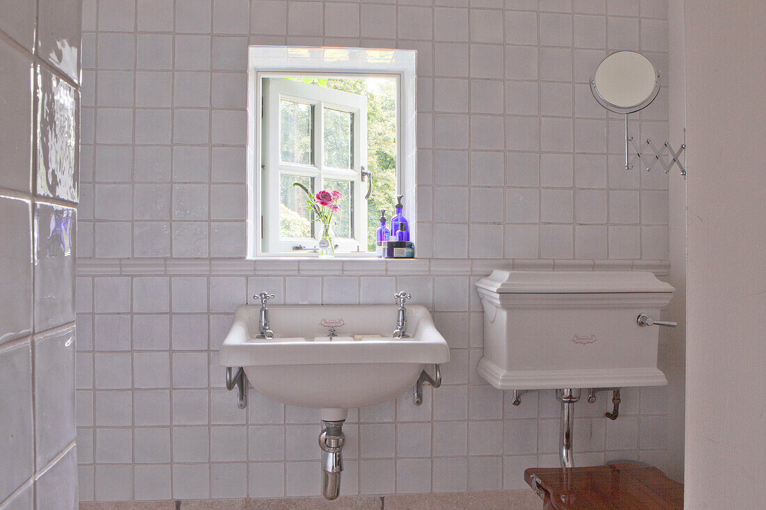 Weiß gefliestes Badezimmer mit offenem Fenster in einem Haus in Surrey, England