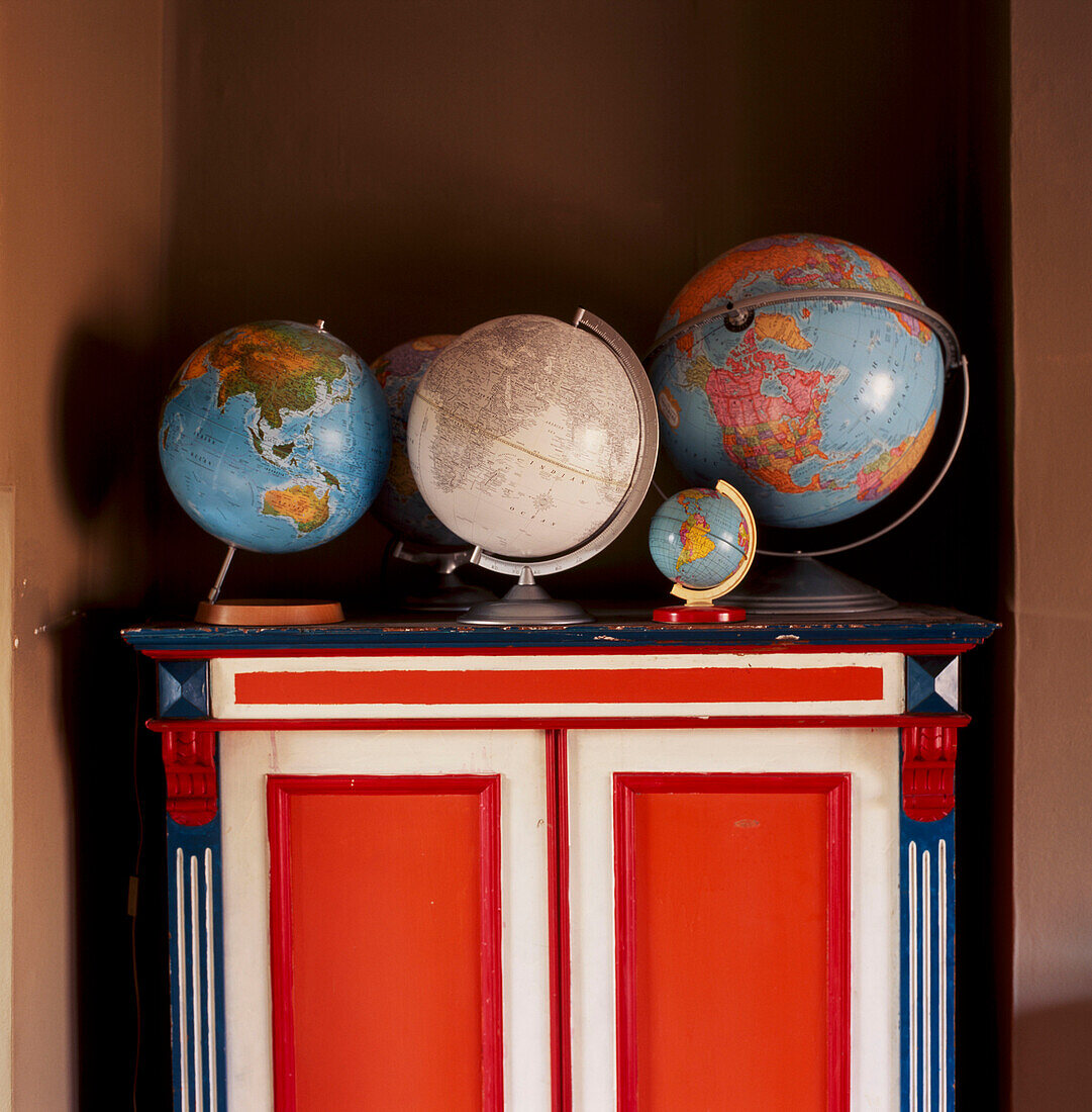Sammlung von Globen auf einem bemalten Schrank