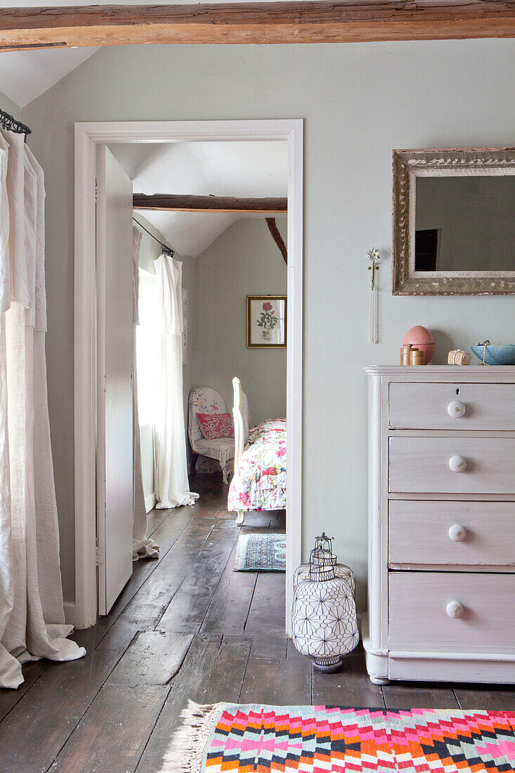 Weiß gestrichene Kommode in einem Zimmer mit Blick durch die Türöffnung, Haus in Großbritannien