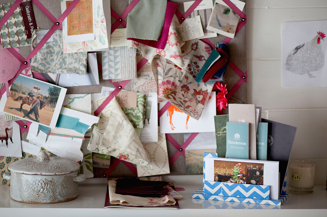Fabric samples and postcards on pinboard in UK home