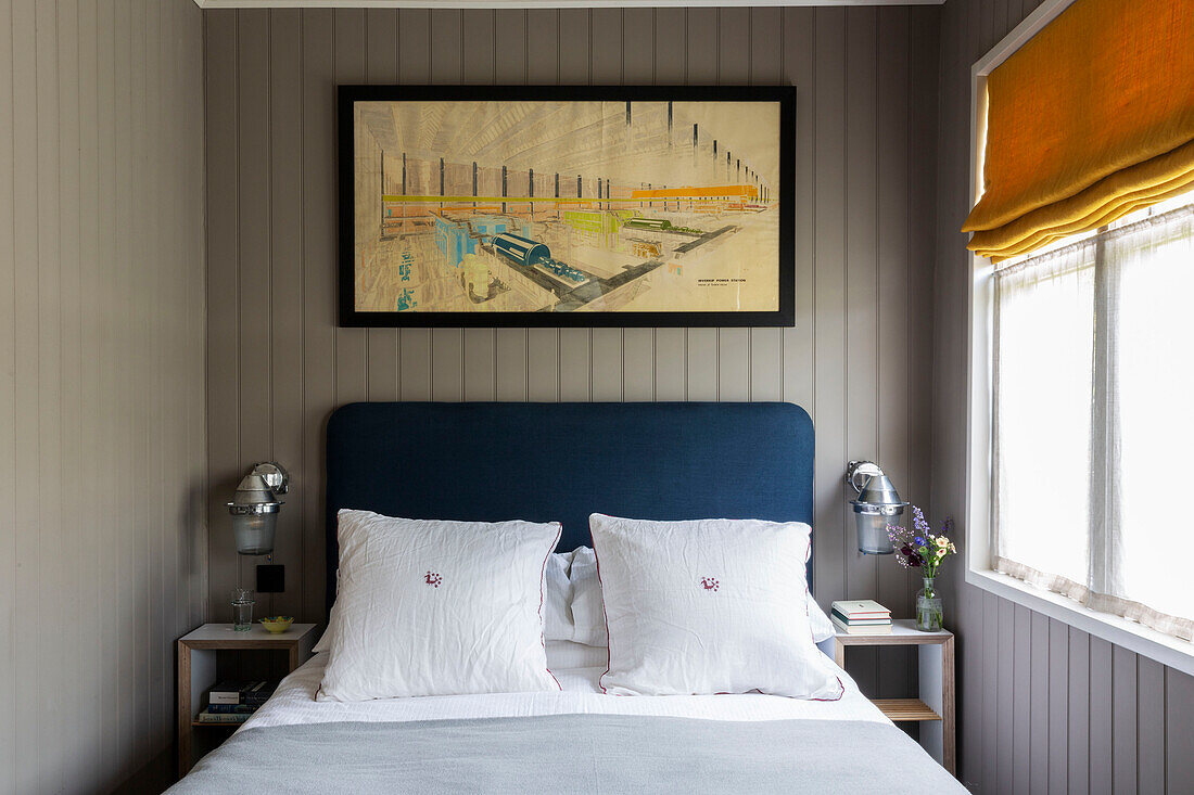 Framed artwork above bed at window in Cirencester home Gloucestershire UK