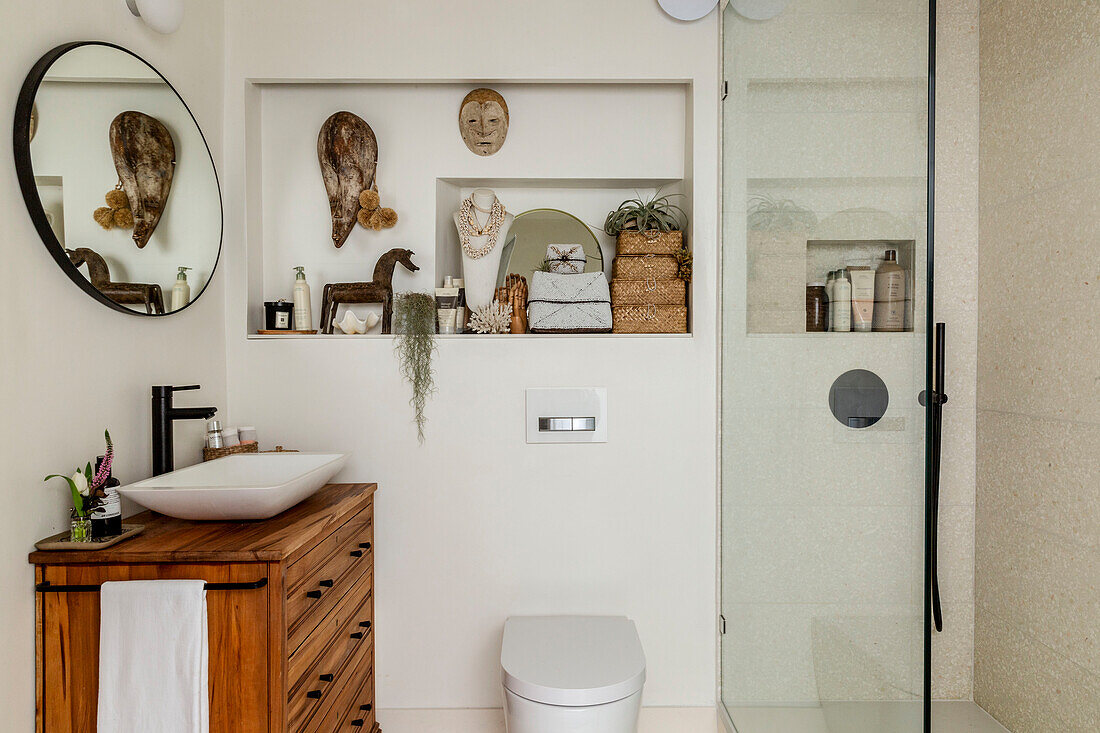 Verschiedene afrikanische Artefakte mit Spiegel über dem Waschtisch im Badezimmer des Cottages in Devon