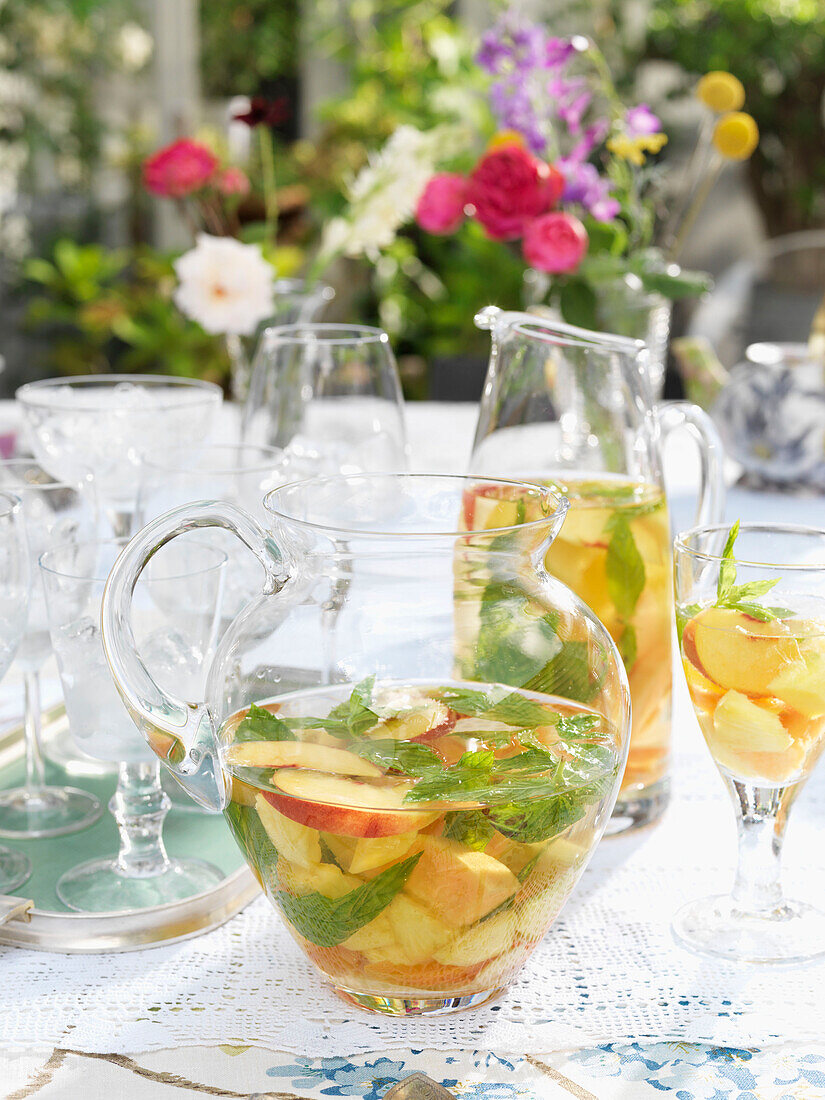 Obst und Minzpunsch in Krug mit Gläsern auf Tisch im Garten Derwent Water, Cumbria, England UK