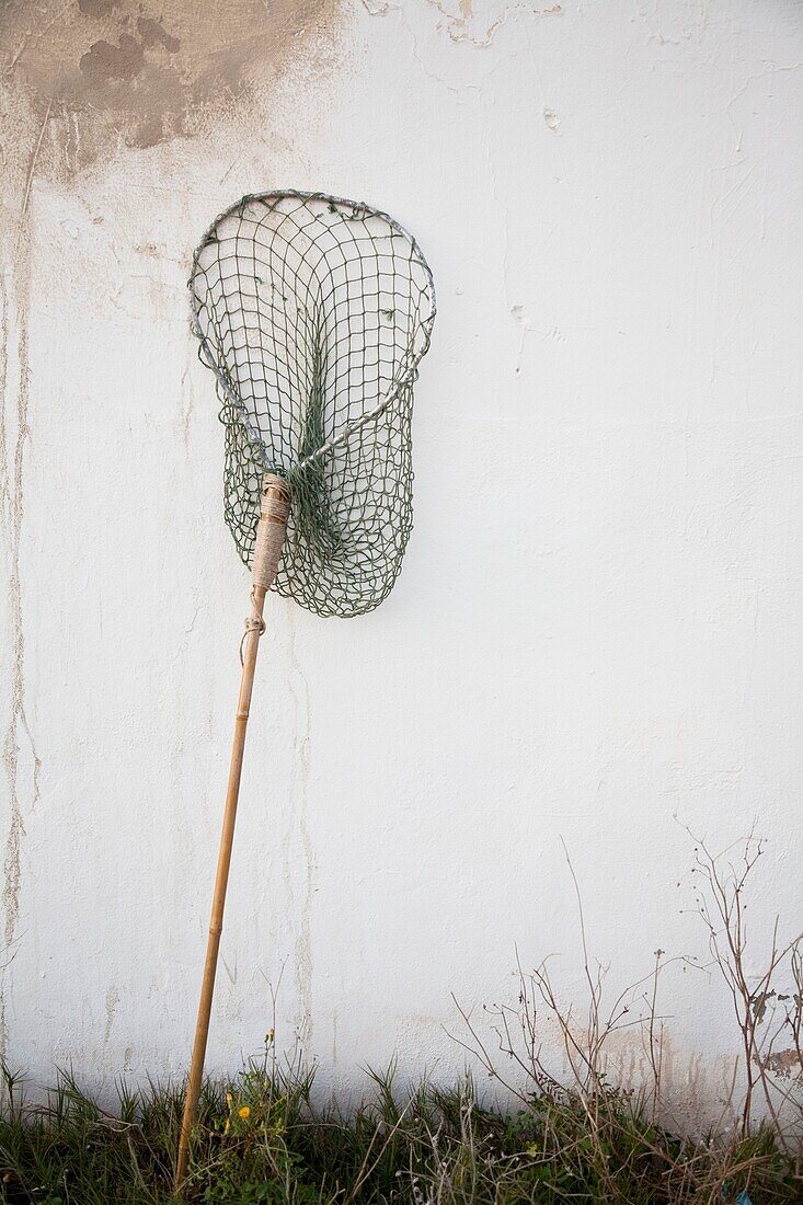 Fishing net leans on white wall, Majorca, Spain