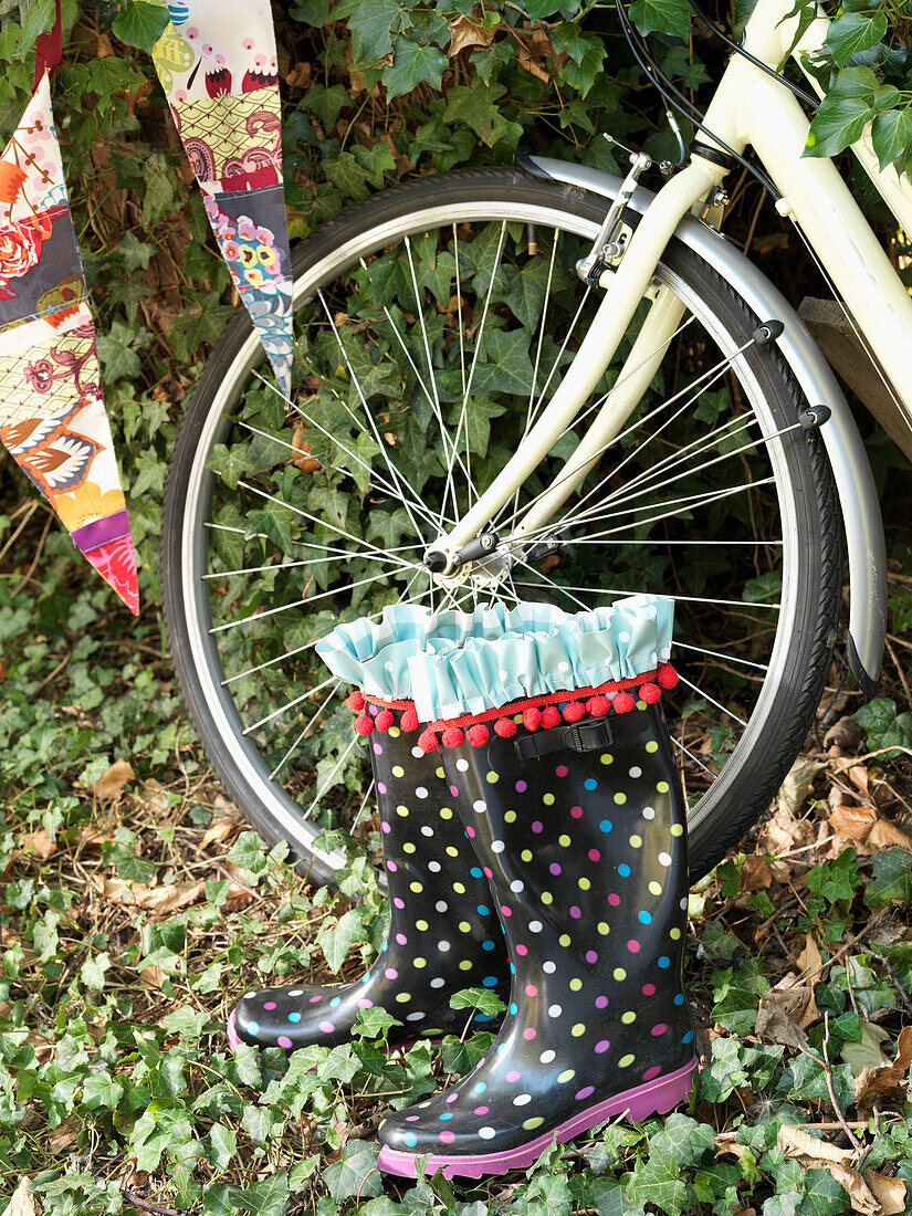Spotty wellington boots and front wheel of bike with bunting London England UK