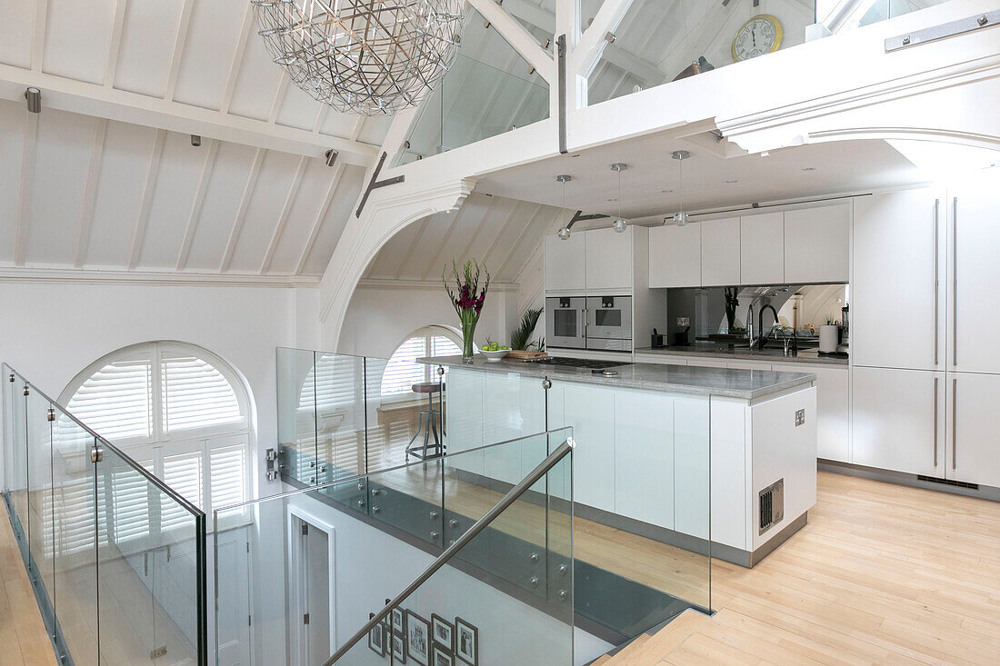 Offene Küche mit polierten Betonoberflächen und Glasgeländer in einem umgebauten Gerichtsgebäude in London UK