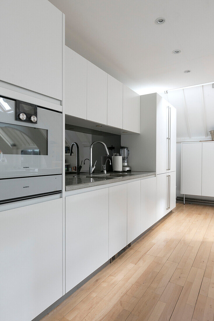 Modern white kitchen in converted London courthouse London UK