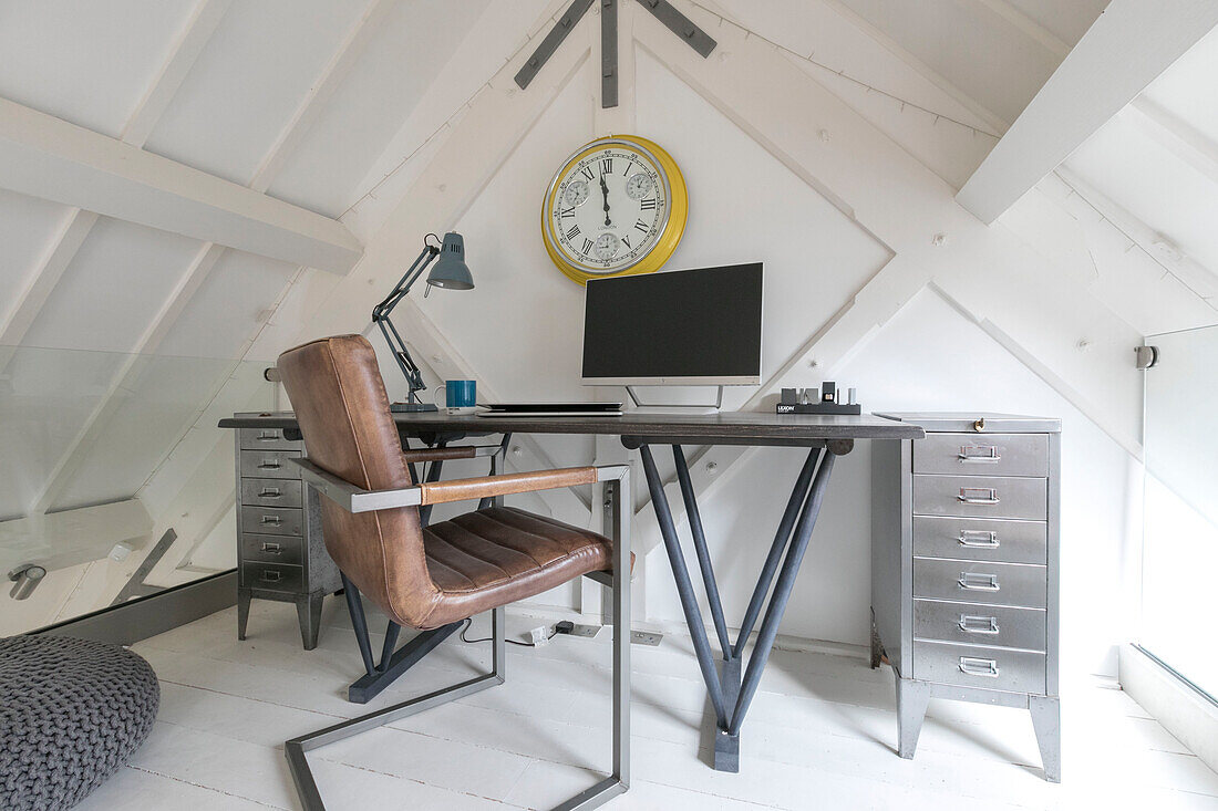 Brown leather chair at desk in converted London courthouse London UK