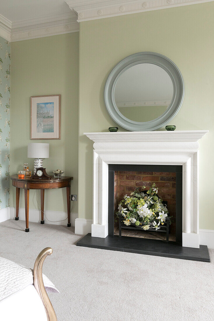 Flowers in brick fireplace with mirror in Georgian Grade II listed Surrey home UK