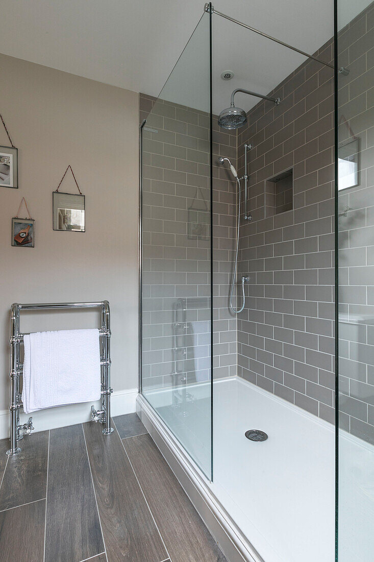 Glass shower cubicle with chrome towel rack in Guildford townhouse Surrey UK