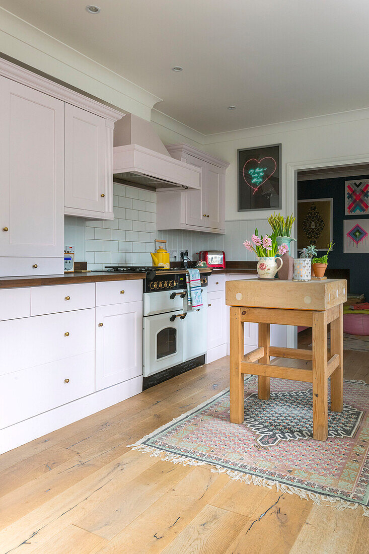 Metzgerblock in einer Küche mit blassrosa Einbaugeräten Guildford cottage Surrey UK
