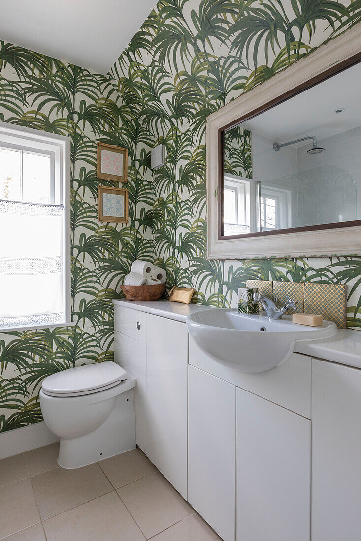 Palmentapete und Vintage-Spiegel in einem Badezimmer in Guildford, Surrey, Großbritannien