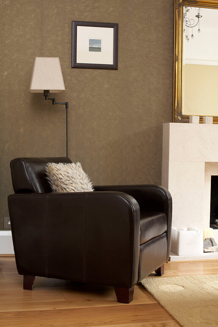 Brown leather armchair at fireside of London home
