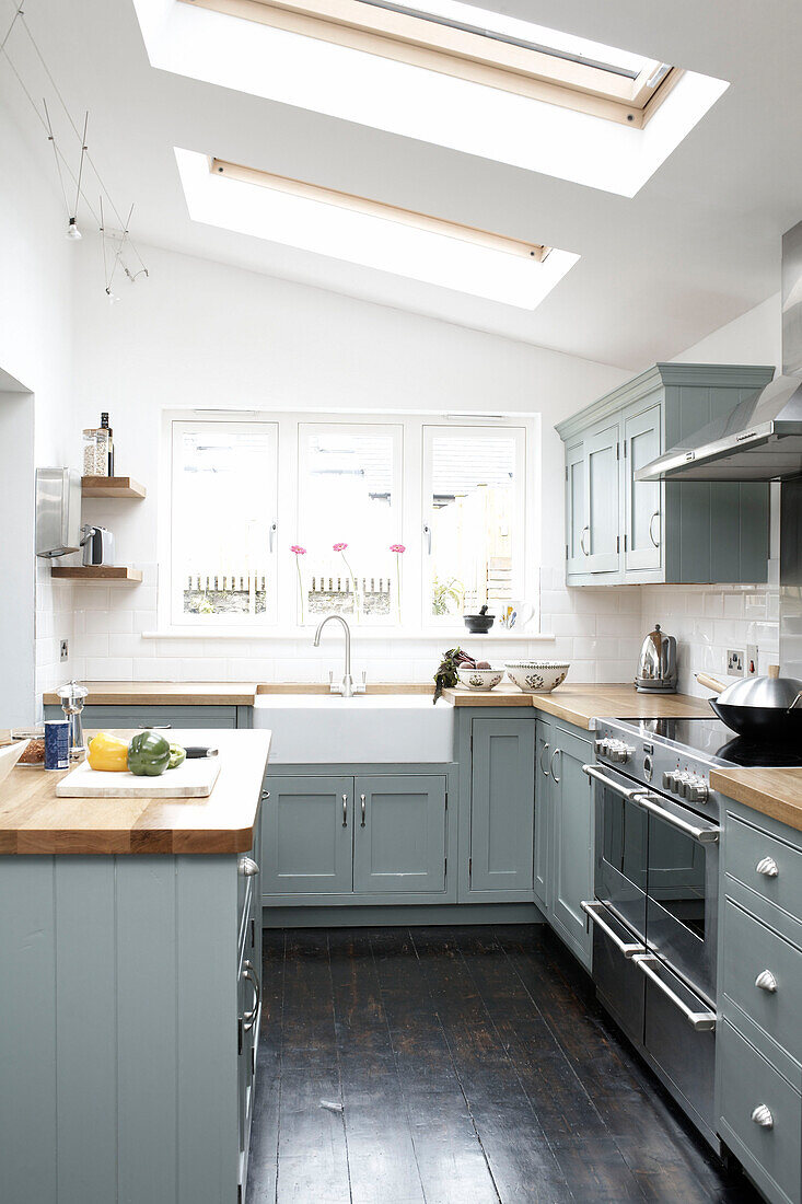 Moderne Küche im Landhausstil mit pastellblauen Schränken und Oberlichtern