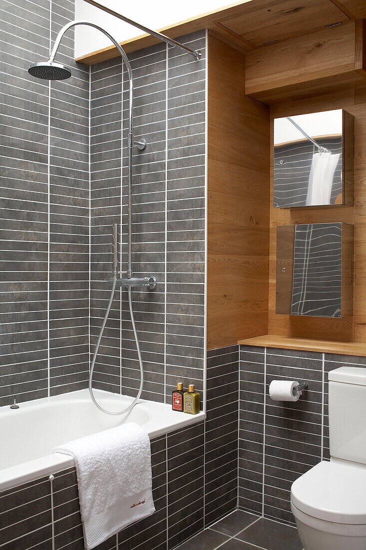 Grey tiled bathroom with metallic showerhead