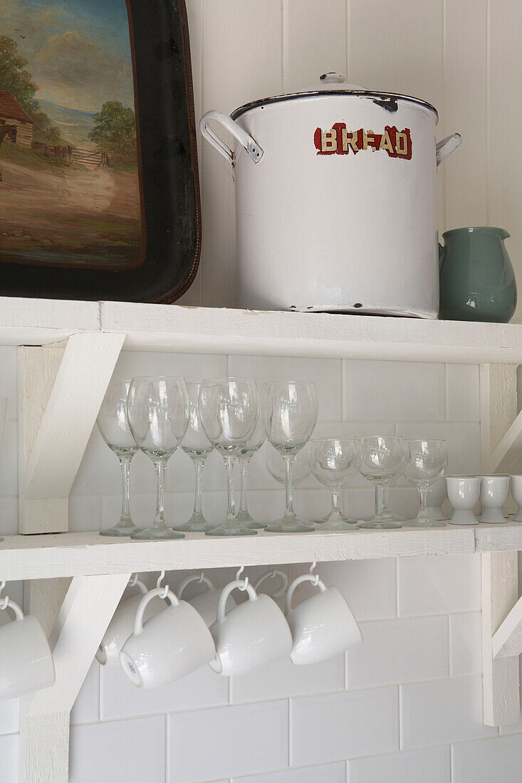 Glasses and cups on open shelving with metal breadbin
