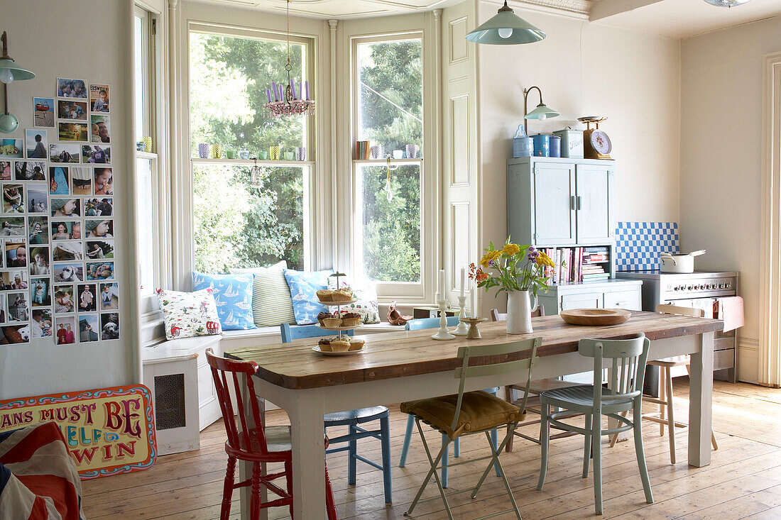 Kitchen table and window seat with postcard display in East Sussex kitchen