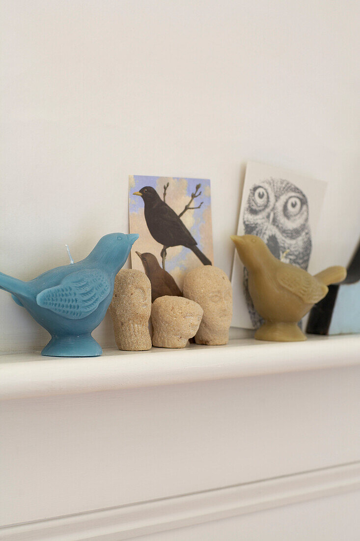 Vogelkerzen und Postkarten mit Ornamenten auf dem Kaminsims eines Hauses in Sussex