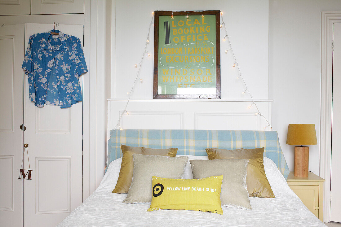 Poster über dem Bett mit Lichtern und Hawaiihemd mit kariertem Kopfteil