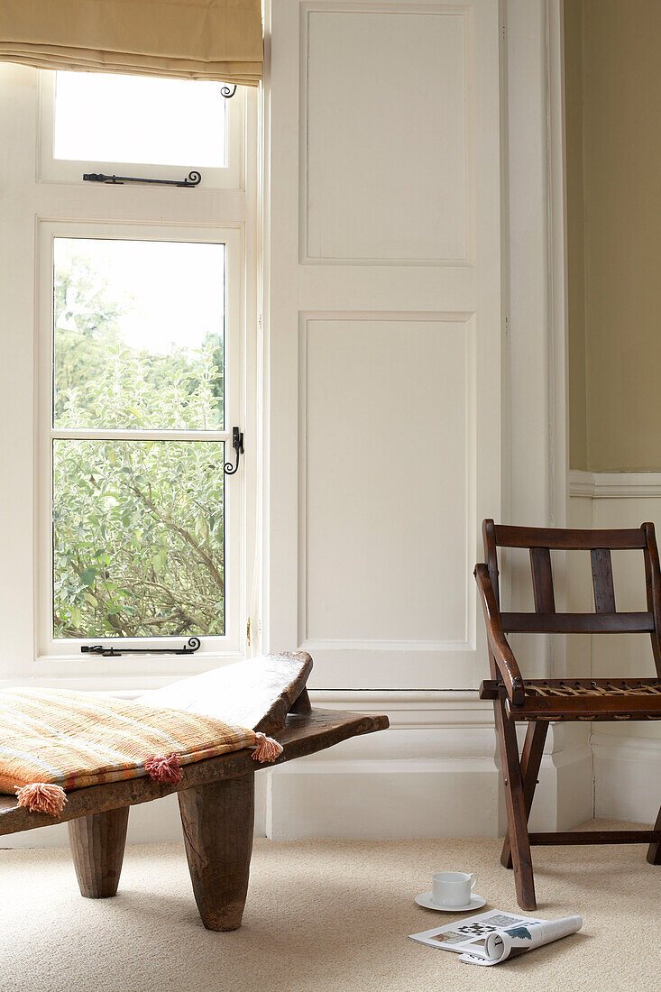 Holzsitzmöbel am Fenster einer britischen Wohnung