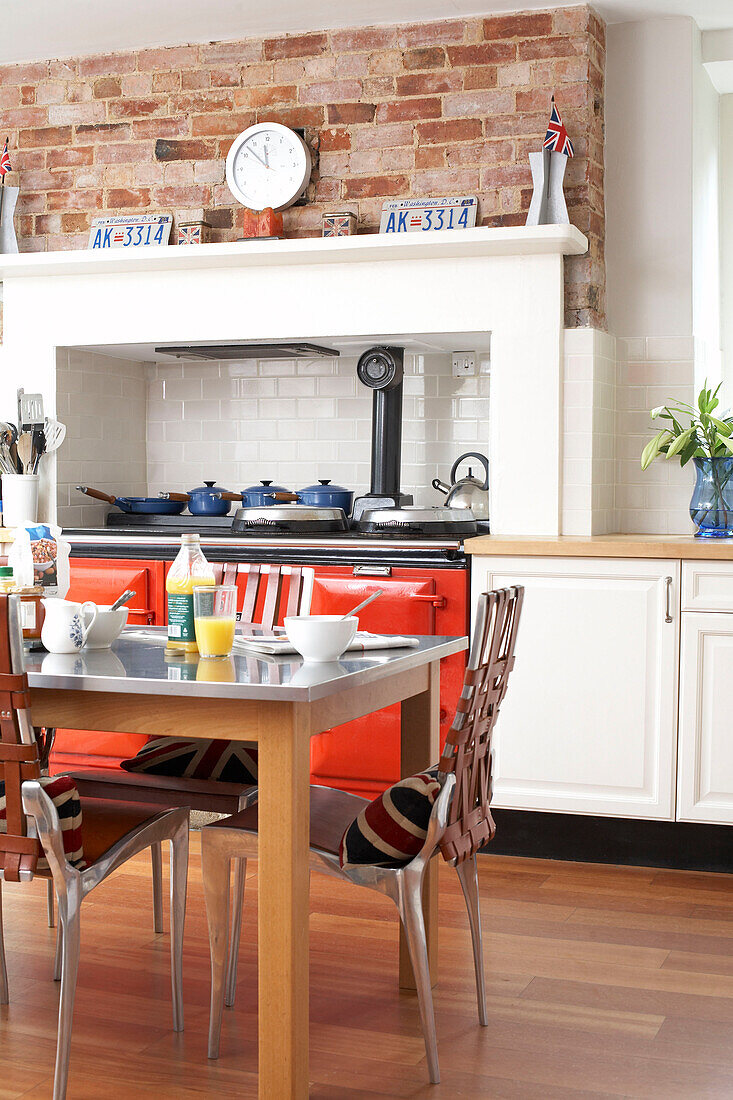 Breakfast table in kitchen with range oven recessed in exposed brick wall