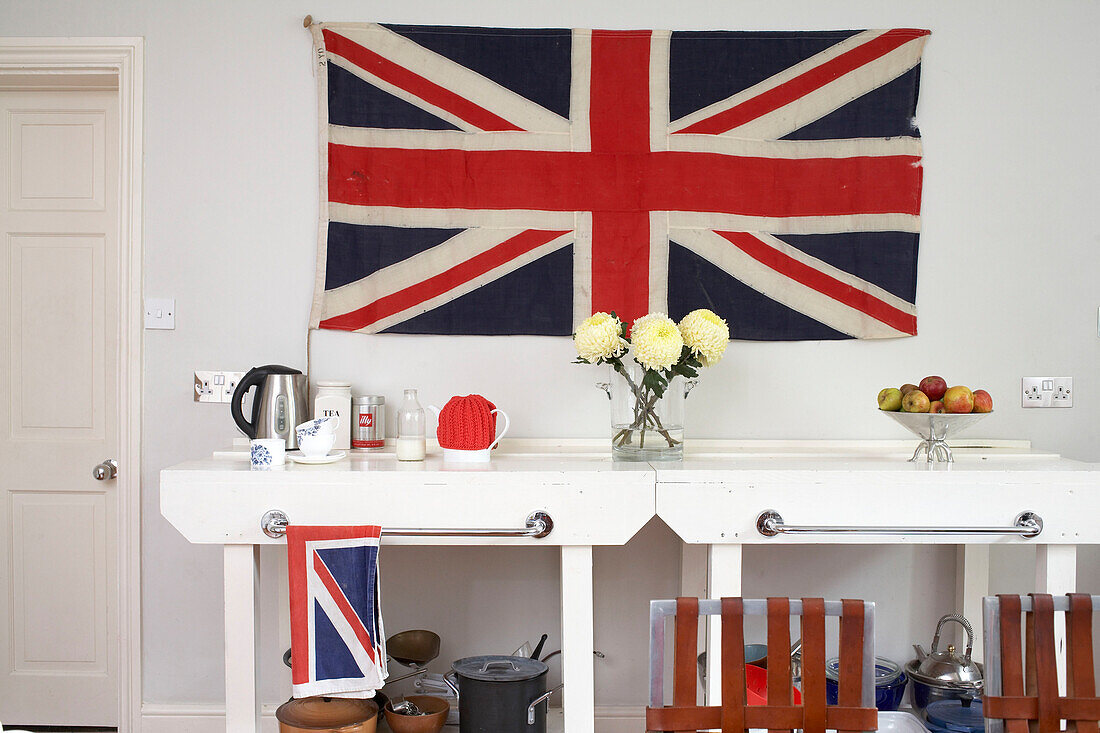 Teekocher auf weiß gestrichenen Tischen mit Handtuchhaltern unter dem Union Jack