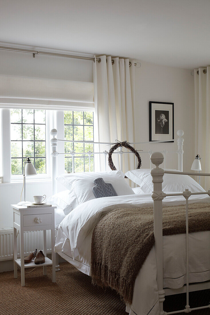 White painted bedroom with leaded glass windowpanes in Isle of Wight home, UK
