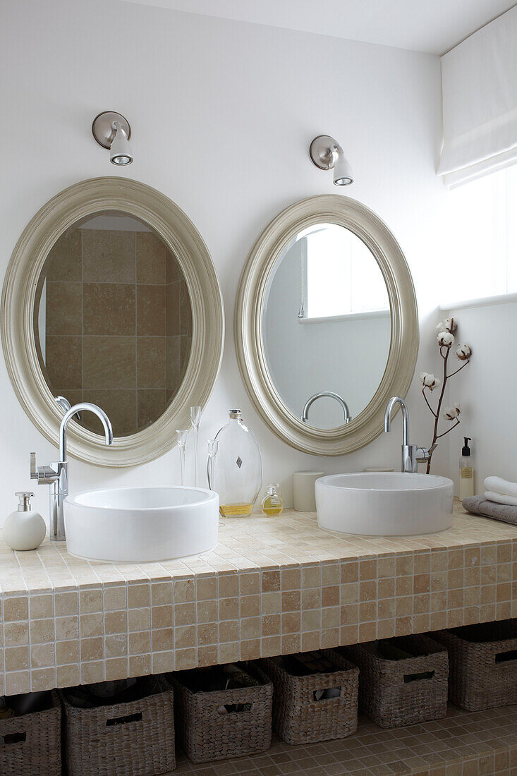 Doppelwaschbecken mit ovalen Spiegeln, Badezimmerdetail in einem Haus auf der Isle of Wight, Vereinigtes Königreich