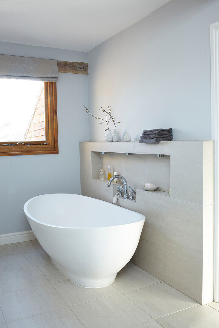Freistehende Badewanne in hellblauem Bad in einem Haus in Kent, England, UK