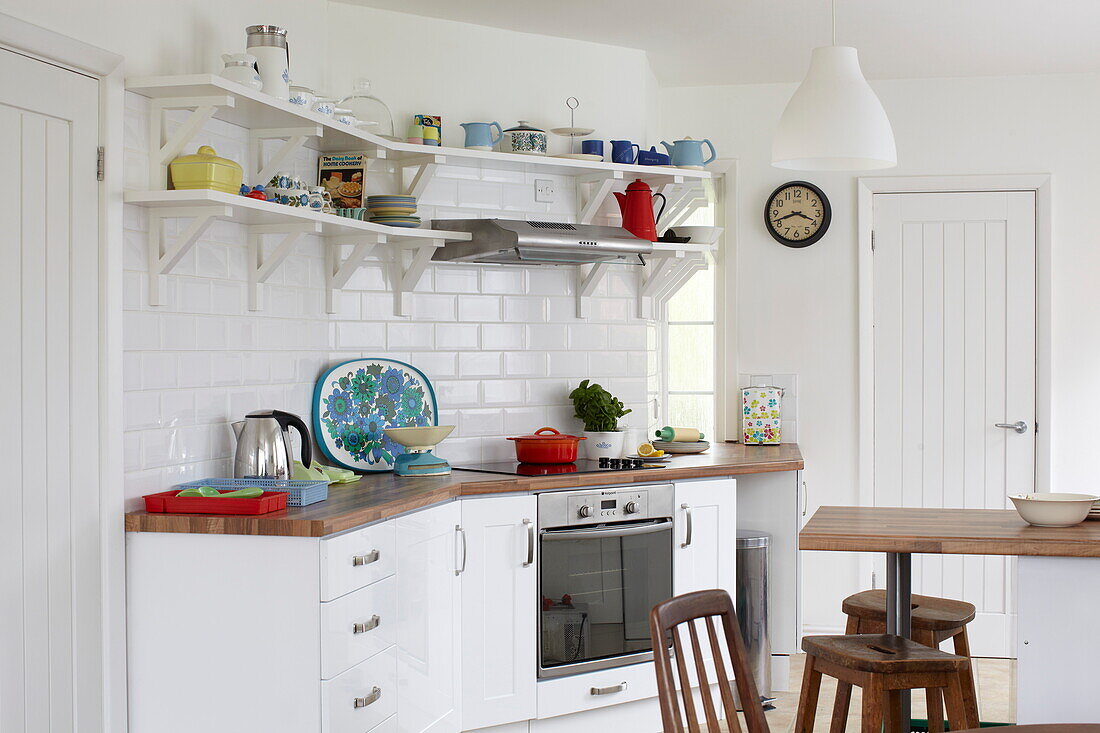 Kitchenware in retro style Bembridge home with wooden breakfast bar and stools, Isle of Wight, UK