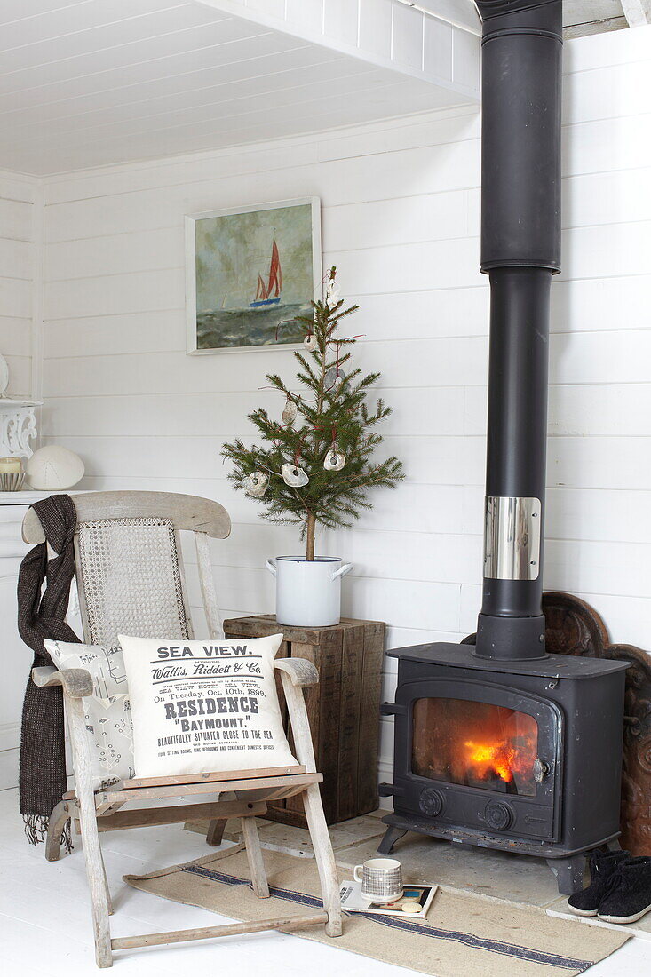 Vintage chair by wood burning stove in Isle of Wight beach house, UK