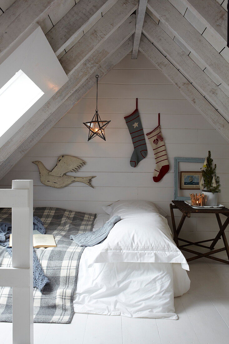 Weihnachtsstrümpfe hängen an der Wand eines Schlafzimmers im Dachgeschoss eines Hauses auf der Isle of Wight, Großbritannien