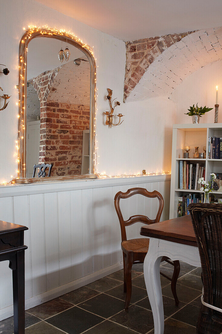 Arched mirror with fairy lights in panelled dining room detail of semi-detached home UK