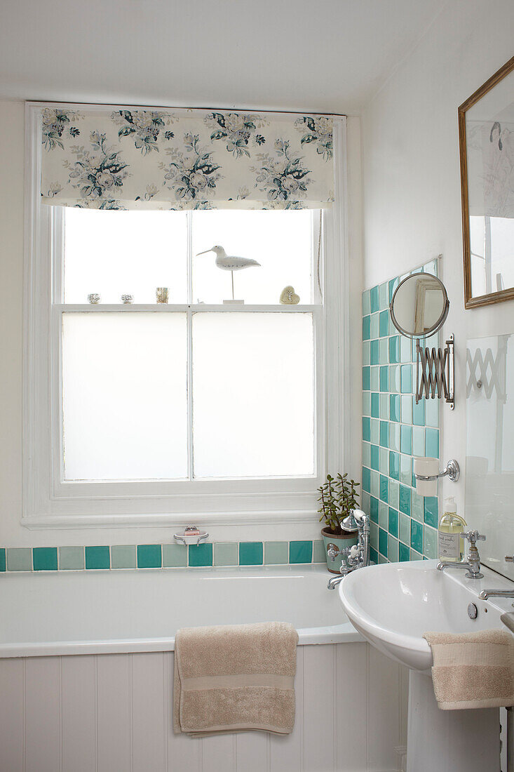 Geflieste Spritzschutzwand und Rasierspiegel im Badezimmer einer Doppelhaushälfte, UK
